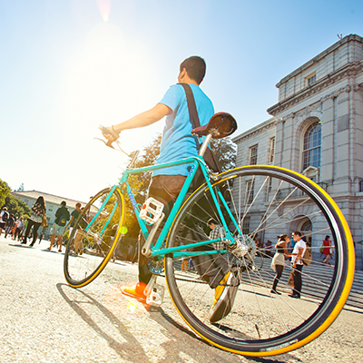 Student walking bike on campus