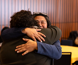 Two staff members embrace